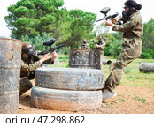 Group of people in full gear playing paintball on shooting range outdoor. Стоковое фото, фотограф Яков Филимонов / Фотобанк Лори