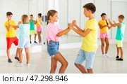 Sporty preteen children learning to dance vigorous jive in pairs. Стоковое фото, фотограф Яков Филимонов / Фотобанк Лори