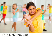 Smiling latin american preteen girl training vigorous dance with tweens. Стоковое фото, фотограф Яков Филимонов / Фотобанк Лори