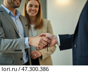 A Couple Receives Keys During a Home Purchase Agreement at a Modern Real Estate Office in the Afternoon Light. Стоковое AI-изображение, AI-художник Sergey Grishin / Фотобанк Лори