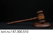 A Wooden Gavel Rests on a Dark Surface, Symbolizing Justice and Legal Authority in a Courtroom Setting. Стоковое AI-изображение, AI-художник Sergey Grishin / Фотобанк Лори