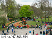 Lisse, Netherlands - April 17, 2019: Numerous people walk in a Keukenhof park. Редакционное фото, фотограф Irina Kuchugurina/Gaudy / Фотобанк Лори