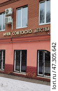 Facade of building is made of red brick. Grilles on windows of first floor. Inscription in Russian: Museum of Soviet Childhood. Russia, Sergiev Posad, February 12, 2025. Редакционное фото, фотограф Ирина / Фотобанк Лори