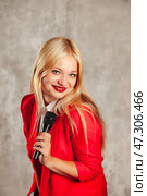 Charismatic Performer in a Bold Red Outfit Captures Attention With Microphone in a Studio Setting. Стоковое фото, фотограф Aleksandr Golubev / Фотобанк Лори