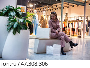 Woman Relaxing in a Shopping Mall While Enjoying a Break Between Store Visits. Стоковое фото, фотограф Aleksandr Golubev / Фотобанк Лори