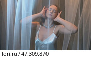 Slow motion video of young female covered with veil. Woman is dressed in a peignoir and wears a necklace and earrings. Стоковое видео, видеограф Сергей Пристяжнюк (Serg Zastavkin) / Фотобанк Лори