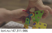 baby child hands screwing nut and screw-bolt plastic game set constructor puzzle. Стоковое видео, видеограф Olesia Kondrateva / Фотобанк Лори