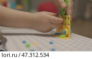 baby child hands screwing nut and screw-bolt plastic game set constructor puzzle. Стоковое видео, видеограф Olesia Kondrateva / Фотобанк Лори