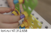 close-up baby child hands screwing nut and screw-bolt in toy constructor game. Стоковое видео, видеограф Olesia Kondrateva / Фотобанк Лори
