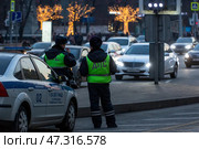 Сотрудник ДПС обеспечивает безопасность движения на улице в центре города Москвы, Россия (2017 год). Редакционное фото, фотограф Николай Винокуров / Фотобанк Лори