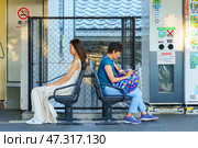 Kyoto, Japan - Sep 23 2024, panoramic view of the JR railway platform with passengers standing and sitting on it, waiting for a train, at daytime, Kyoto, Japan. Редакционное фото, фотограф Сергей Богомяко / Фотобанк Лори