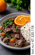 Experience the richness of Brazilian feijoada with tender pork in black bean stew served with rice and orange slices. Стоковое AI-изображение, AI-художник 123 12 / Фотобанк Лори