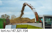 Claas jaguar 870 forage harvester loading chopped silage into trailer for transport to storage. Стоковое фото, фотограф Mikhail Davidovich / Фотобанк Лори