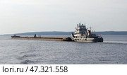 Буксир-толкач с баржами идёт вверх по Чебоксарскому водохранилищу (река Волга) (2020 год). Редакционное фото, фотограф Алексей Иванов / Фотобанк Лори