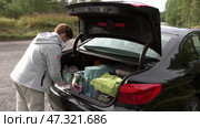 Женщина протирает багажник машины на стоянке. Май. A woman wipes the trunk of a car in car park. May. Редакционное видео, видеограф Горшков Александр / Фотобанк Лори