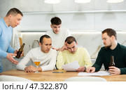 Group of men supporting troubled friend reading legal notice. Стоковое фото, фотограф Яков Филимонов / Фотобанк Лори