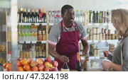 African male offers to buy wine woman buyer, shows assortment, Стоковое видео, видеограф Яков Филимонов / Фотобанк Лори