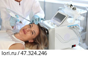 Young woman undergoing device-driven facial treatment using ion bubble pen attachment for gentle exfoliation, deep hydration and skin revitalization at cosmetic medicine clinic. Стоковое видео, видеограф Яков Филимонов / Фотобанк Лори