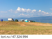 BAIKAL LAKE, OLKHON ISLAND, KHARANTSY VILLAGE, IRKUTSK REGION, RUSSIA - August 04, 2024:  Tourists rest in tent camp on shore of lake near village of Kharantsy. Summer travels on Olkhon Island. Редакционное фото, фотограф Виктория Катьянова / Фотобанк Лори