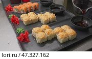 Sushi preparation with fresh ingredients in a busy kitchen at a popular restaurant. Стоковое видео, видеограф Сергей Толмачёв / Фотобанк Лори