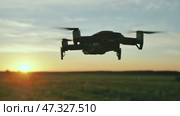 The drone hovers in flight at sunset. Стоковое видео, видеограф Mikhail Davidovich / Фотобанк Лори