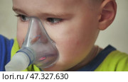 The kid breathes in a mask with an inhaler. Стоковое видео, видеограф Mikhail Davidovich / Фотобанк Лори