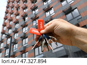 Vidnoe, Russia - Aug 10, 2022. Keys to the new building of the construction company PIK in a man's hand. Редакционное фото, фотограф Володина Ольга / Фотобанк Лори