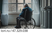 A lonely old man sits in a wheelchair and looks out the window. Loneliness and old age. lonely elder thoughtful sad old man look outside windows in bedroom at retirement home. Стоковое AI-видео, аниматор Sergey Grishin / Фотобанк Лори