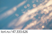 Soft light creates a dreamy ambiance with shimmering bokeh effects on a blue background. Стоковое AI-изображение, AI-художник Сергей Толмачёв / Фотобанк Лори