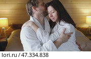Mature couple in a white bathrobes hugging each other kissing at home bedroom. Intimate Moment. Tender embrace shared between a loving middle age man and woman, husband and wife. Deep love. Vacation. Стоковое видео, видеограф Марина Демидюк / Фотобанк Лори