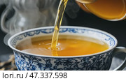 Hot tea pouring into blue and white china cup. Стоковое AI-видео, аниматор Юрий Поздников / Фотобанк Лори