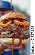 Delicious barbecue sauce drizzled on double burger with crispy onion rings. Стоковое AI-видео, аниматор Юрий Поздников / Фотобанк Лори