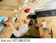 Girl conquering inverted bouldering wall at climbing gym. Стоковое фото, фотограф Яков Филимонов / Фотобанк Лори