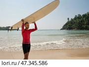 Handsome man surfer carrying surf and comes back from surfing. Outdoors. Стоковое фото, фотограф Светлана Лажко / Фотобанк Лори