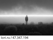 The silhouette of a lone man standing in a deserted, foggy landscape. The entire space is shrouded in thick gray fog, through which a bright horizontal line of light cuts, like a border between worlds. The man stands motionless, facing the light, against a backdrop of dark, rocky ground with sparse bushes. The atmosphere of the scene is dark, mysterious and cinematic - like an illustration of a philosophical parable or a scene from a science fiction film. Стоковое AI-изображение, AI-художник Анна Кривицкая / Фотобанк Лори