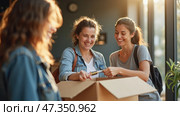 Three cheerful friends gather around a cardboard box, excitedly unboxing its contents in a bright, warmly lit room, showcasing their friendship and teamwork. Стоковое AI-изображение, AI-художник Sergey Grishin / Фотобанк Лори