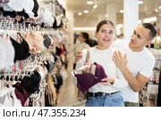Young couple choosing nice brassiere in clothing store. Стоковое фото, фотограф Яков Филимонов / Фотобанк Лори