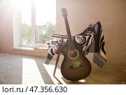 Guitar. Guitar chords. Acoustic guitar. Music. Musical background. An image of an acoustic guitar in a room with a retro armchair. Hard light. Shadows. Стоковое фото, фотограф Photojuli / Фотобанк Лори