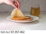 Handling a fresh Kombucha SCOBY along with brewed tea for an exciting brewing experience. Стоковое фото, фотограф Ольга Коваленко / Фотобанк Лори