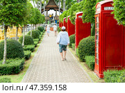 Pattaya, Thailand - December 05, 2018: Tourists walk along the alley in Nong Nooch tropical garden. Редакционное фото, фотограф Игорь Дашко / Фотобанк Лори