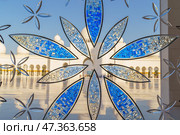 Abu Dhabi, United Arab Emirates - Jan 10 2024, Close-up view of the stained glass window with a floral pattern, in the Grand Mosque of Sheikh Zayed, at daytime, Abu Dhabi, United Arab Emirates. Редакционное фото, фотограф Сергей Богомяко / Фотобанк Лори