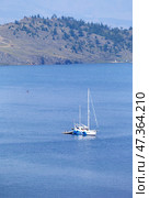 Summer holidays on Baikal Lake. Tourists travel on a pleasure sailing yacht and fish in the bays of the Small Sea on July. Concept of water tourism and outdoor recreation. Seascape. Natural background. Стоковое фото, фотограф Виктория Катьянова / Фотобанк Лори