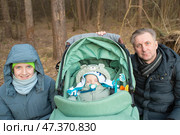 Портрет мужчины с двумя детьми. Отец с сыном-подростком и сыном-младенцем, спящим в коляске. Фокус на отце. Стоковое фото, фотограф Яна Проничева / Фотобанк Лори