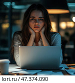 A young woman with a tense, worried expression sits at a laptop in a dark office. Her elbows are resting on the table, her hands are supporting her head, and her brows are furrowed - she is clearly tired, overwhelmed, or facing a difficult task. Papers are scattered around, a cup of coffee is lying around, and the dim light of a lamp creates a warm accent against the cool lighting. The scene conveys an atmosphere of overwork, late-night work, or emotional burnout. Стоковое AI-изображение, AI-художник Анна Кривицкая / Фотобанк Лори