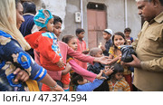 Agra, India - December 12, 2018 Banana treats for children from poor areas of Agra city. Редакционное фото, фотограф Mikhail Davidovich / Фотобанк Лори