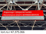 Информационные указатели в аэропорту Шереметьево, Москва. Red sign at Sheremetyevo Airport, exit to Terminals B, C, D. Exit to Moscow city. Convenient informational navigation and markings for tourists and visitors. Редакционное фото, фотограф Ирина Михайличенко / Фотобанк Лори