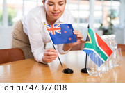 Unrecognizable girl set midget flags of South Africa and Australia before international negotiations. Стоковое фото, фотограф Яков Филимонов / Фотобанк Лори