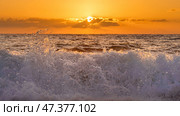 Alanya, Antalya, Türkiye, Turkey, Panoramic view of the undulating Mediterranean Sea with waves at sunset, bright orange sun in the sky and clouds around (2022 год). Стоковое фото, фотограф Сергей Богомяко / Фотобанк Лори