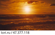 Alanya, Antalya, Türkiye, Turkey, Panoramic view of the undulating Mediterranean Sea with waves at sunset, bright orange sun in the sky and clouds around (2023 год). Стоковое фото, фотограф Сергей Богомяко / Фотобанк Лори