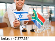 Blurry girl set midget flags of South Africa and Israel before international negotiations. Стоковое фото, фотограф Яков Филимонов / Фотобанк Лори